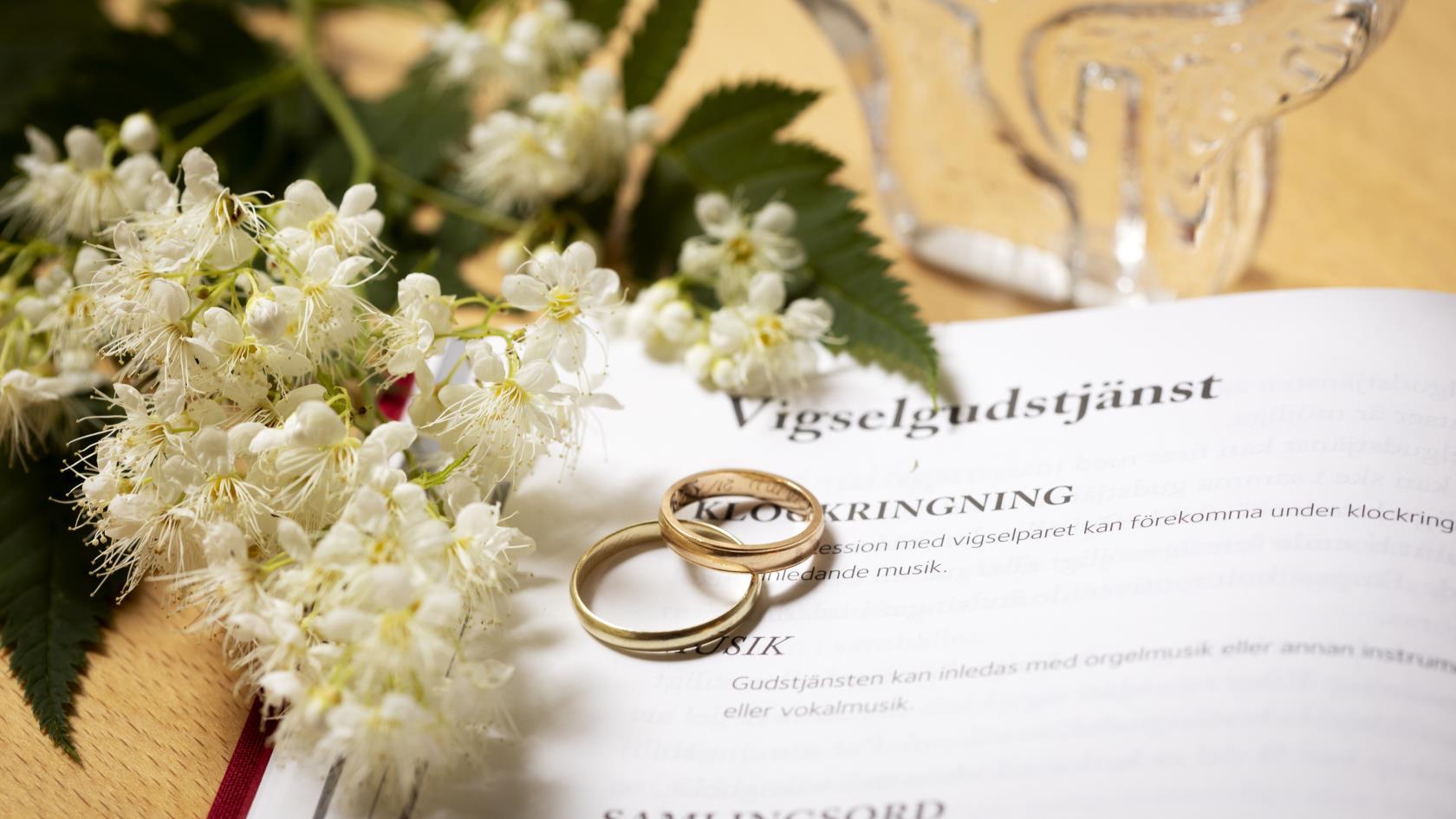 Vigselgudstjänst agenda med ringar och blommor