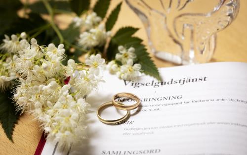 Vigselgudstjänst agenda med ringar och blommor