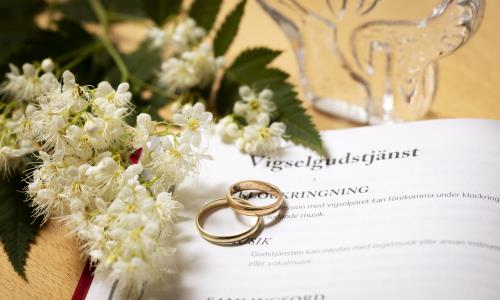 Vigselgudstjänst agenda med ringar och blommor