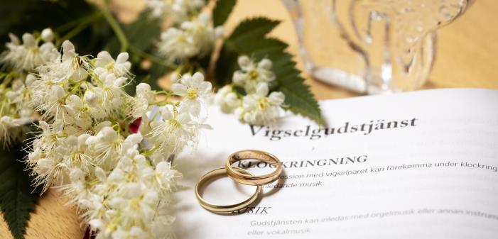 Vigselgudstjänst agenda med ringar och blommor