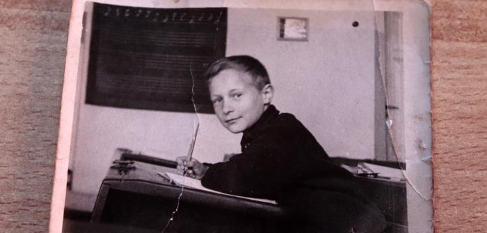 Svartvitt foto med pojek i skolbänk