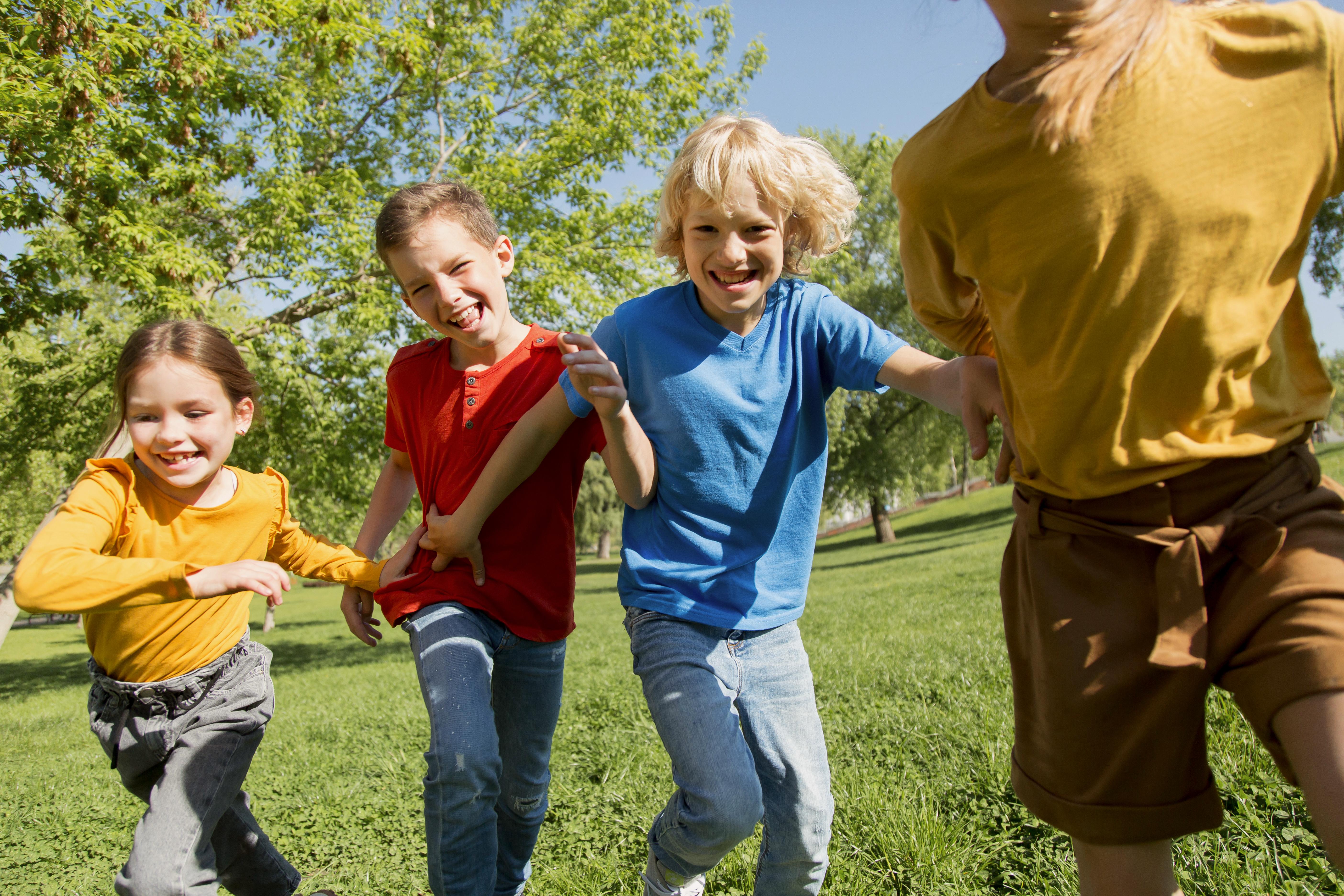 Springande barn på en grön äng