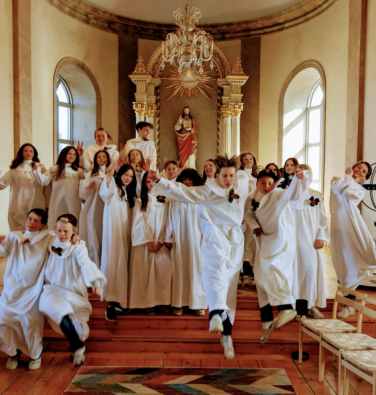 Konfirmander som hoppar i kyrkan.