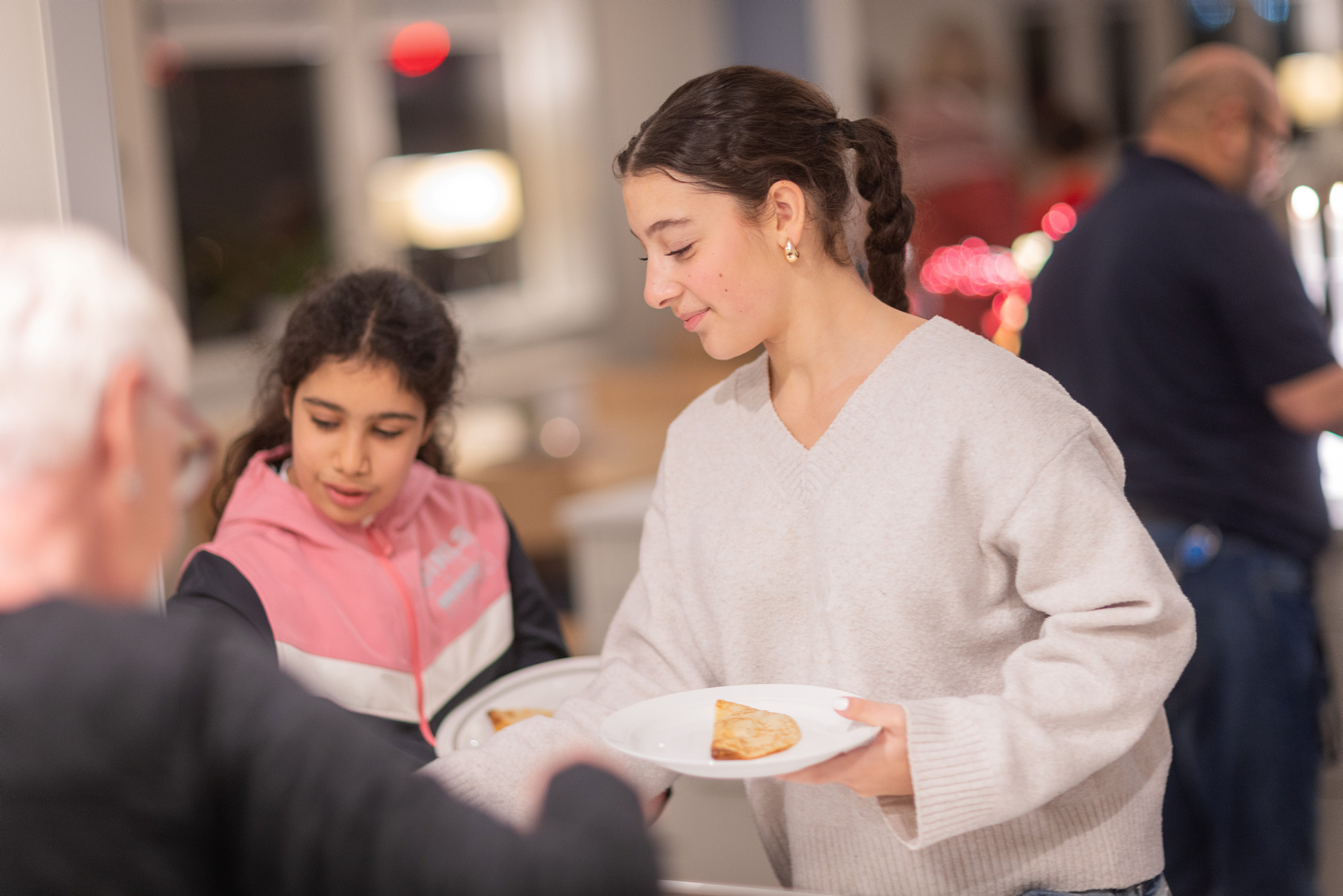 Ungdomar som håller i tallrik med pannkaka.