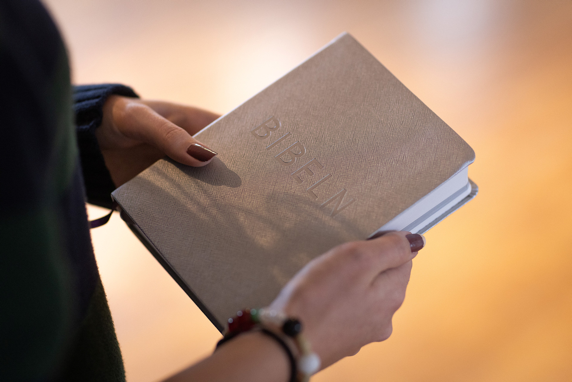 Händer som håller i en bibel.