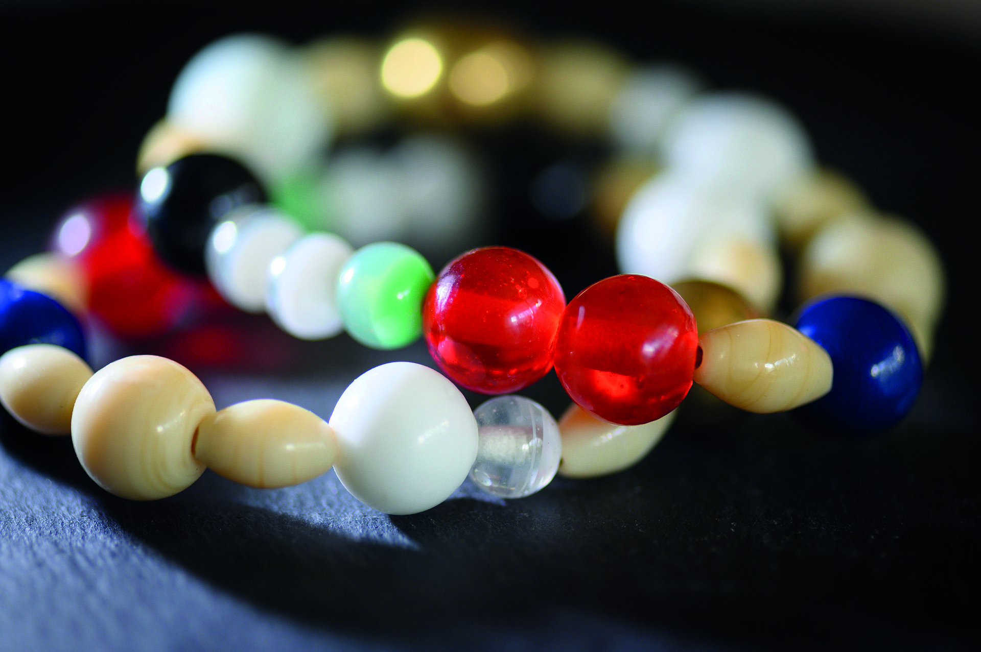 Närbild på armbandet Frälsarkransen med glaspärlor i olika färger.