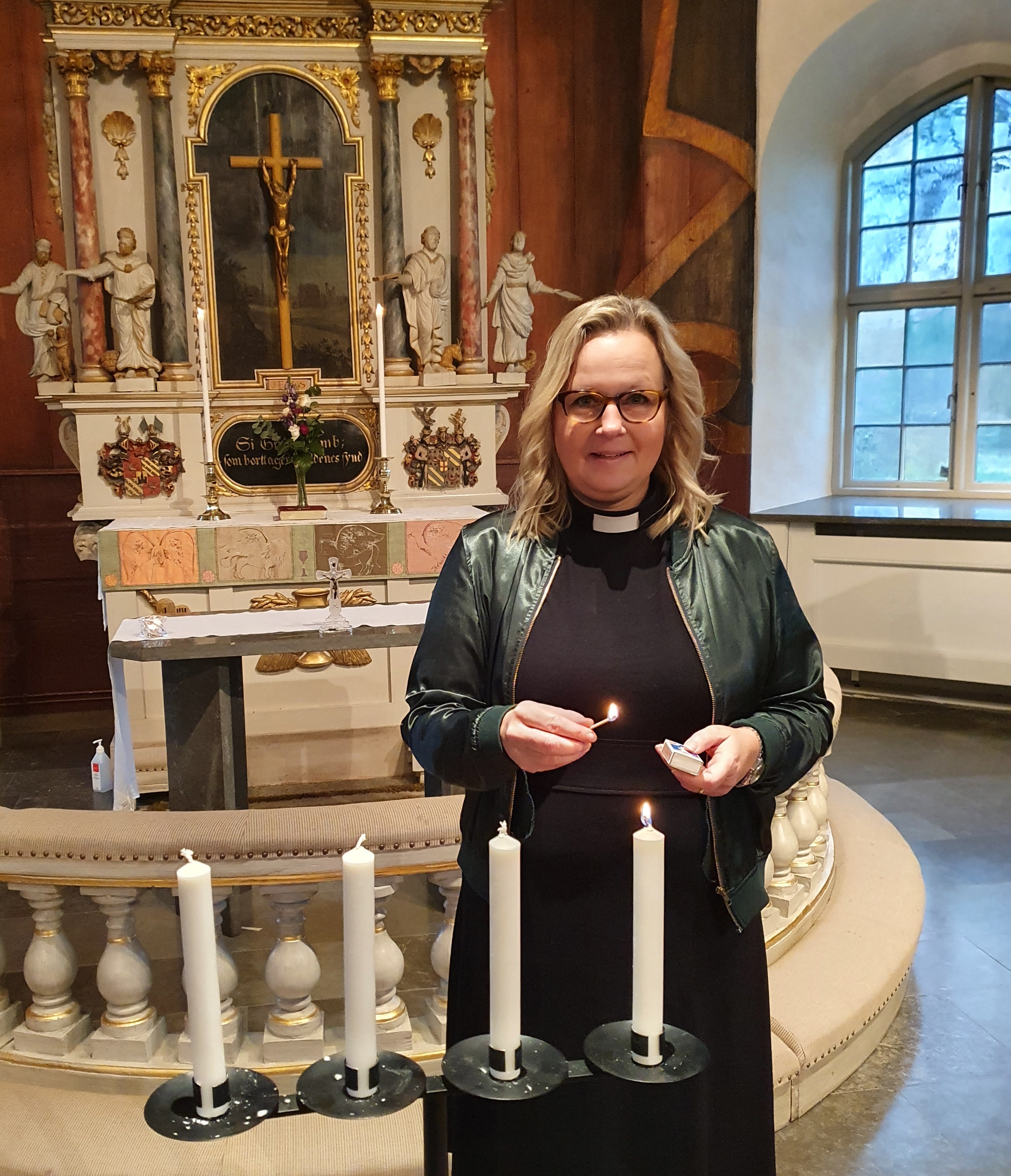 Jannica Norén tänder det första adventsljuset i Stora Lundby kyrkas adventsljusstake.