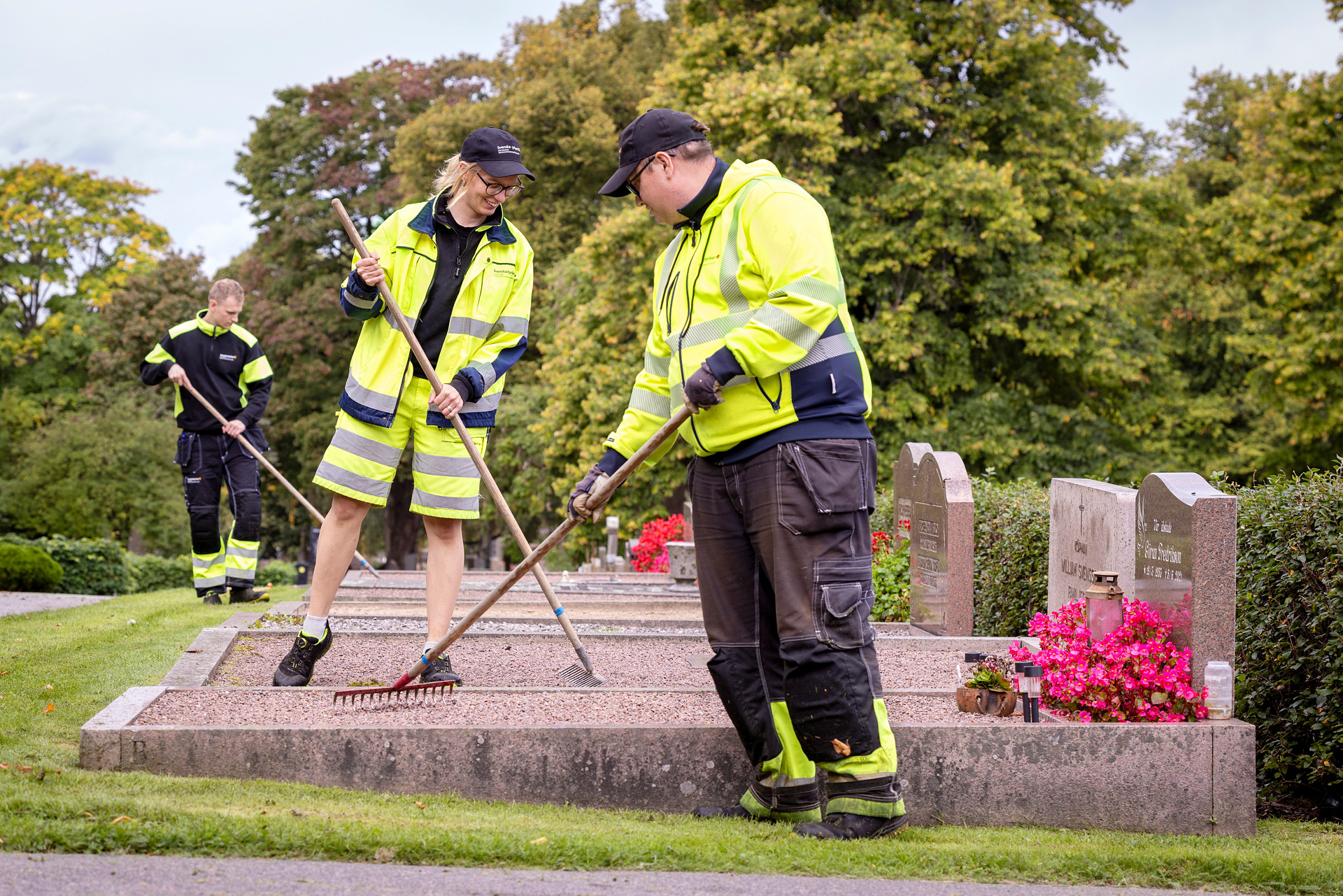 Vaktmästare som krattar på kyrkogården