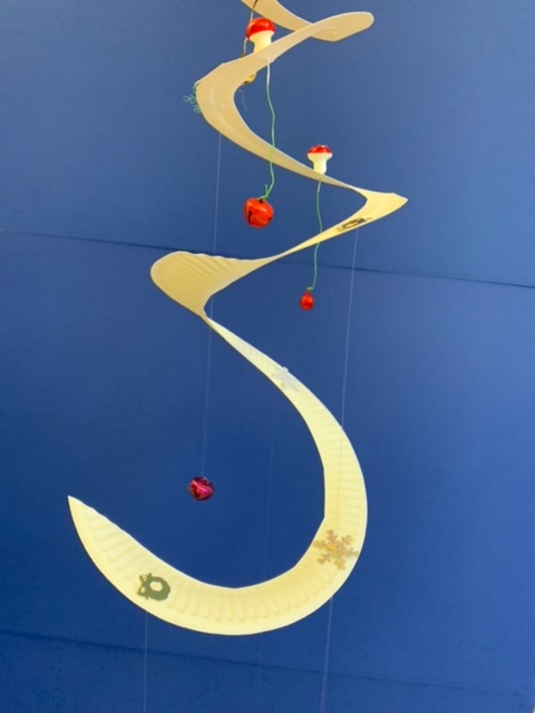 En girlang av en papperstallrik, pyntad med pärlor och paljetter.