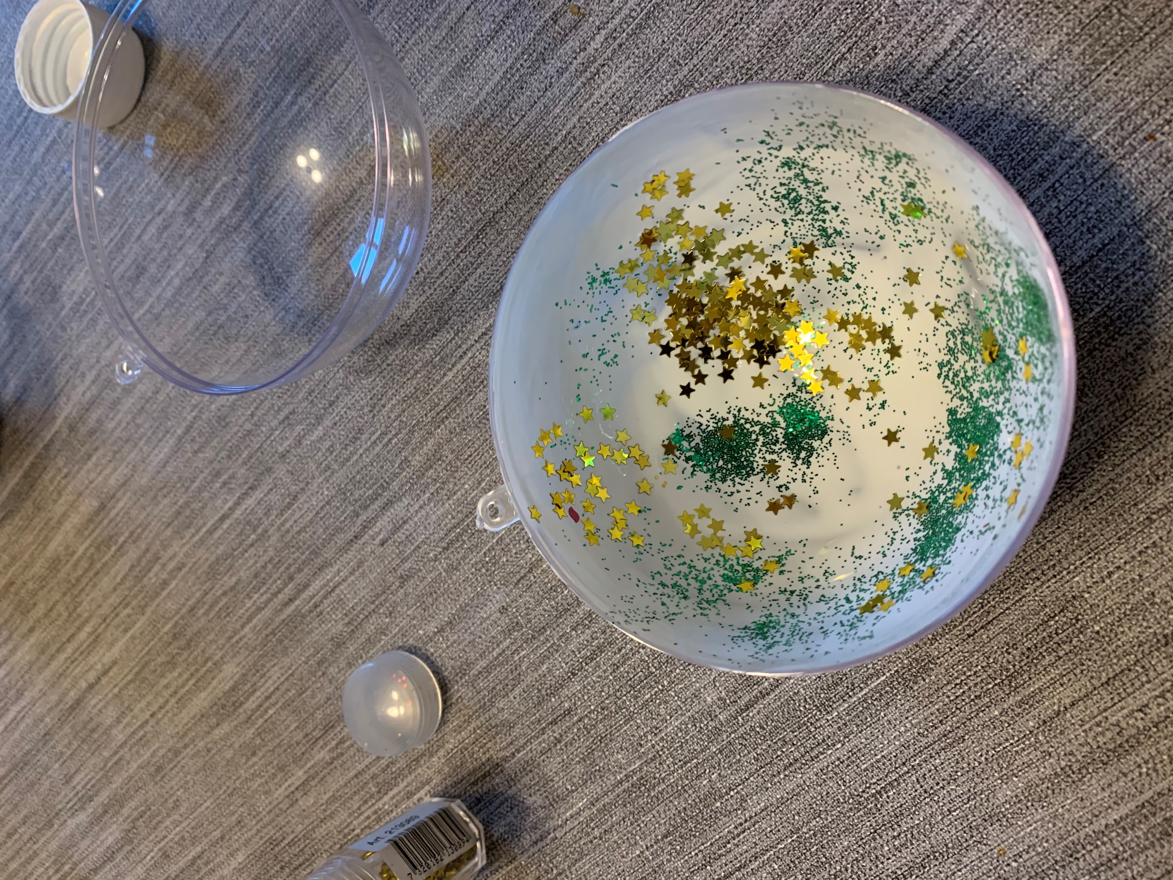 En julkula som pysslas ihop med lim och glitter.