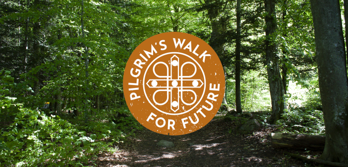 En grön, lummig skog, det kommer in solstrålar från utsidan. I mitten är en orange och vit logotyp med med texten "Pilgrim´s Walk for Future".
