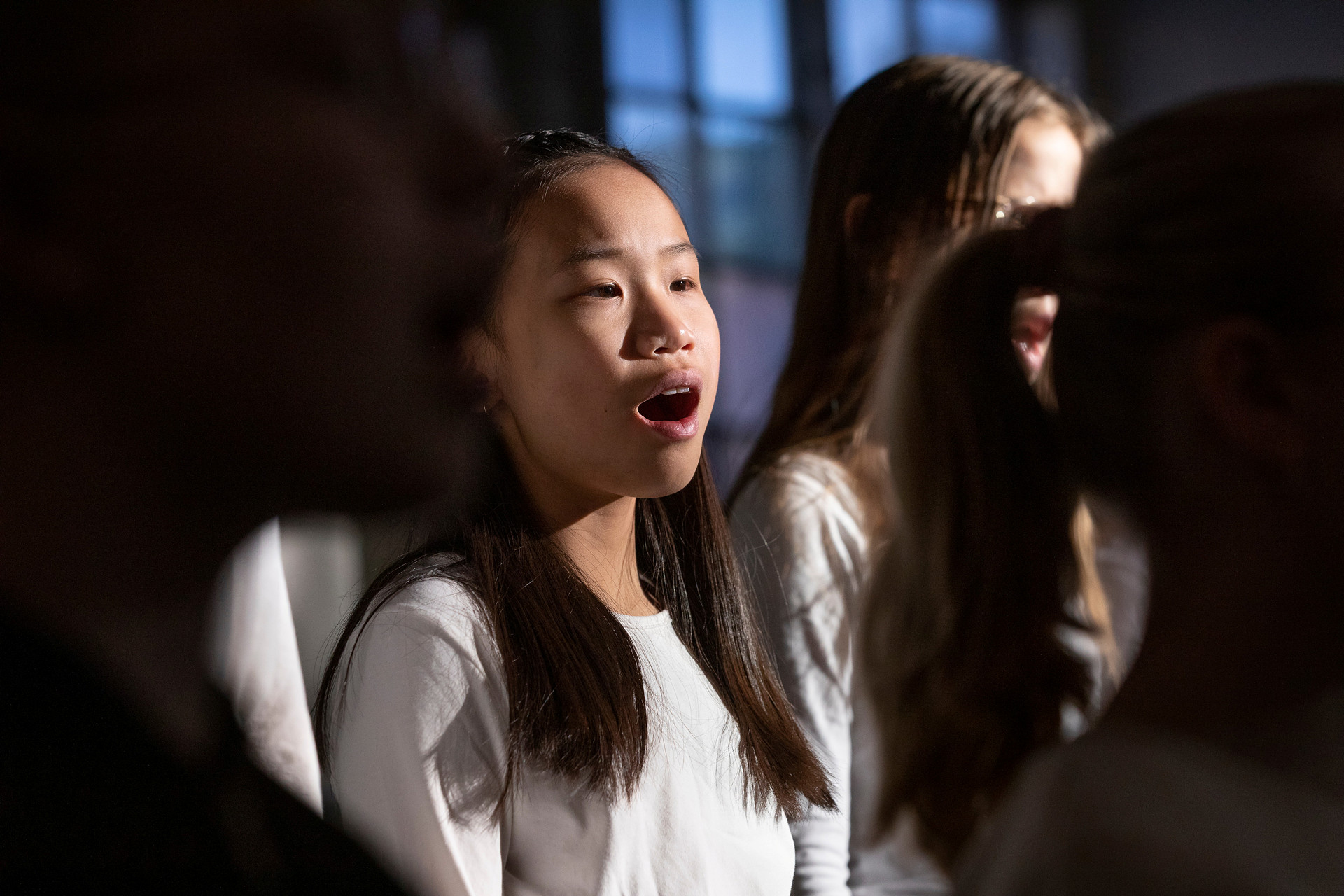 En flicka sjunger i en nedsläckt kyrka men en strålkastare på  sig