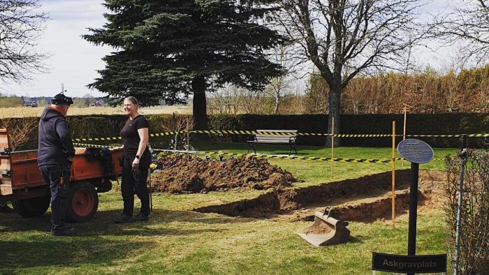 Två vaktmästare arbetar glada på en kyrkogård i Töreboda.