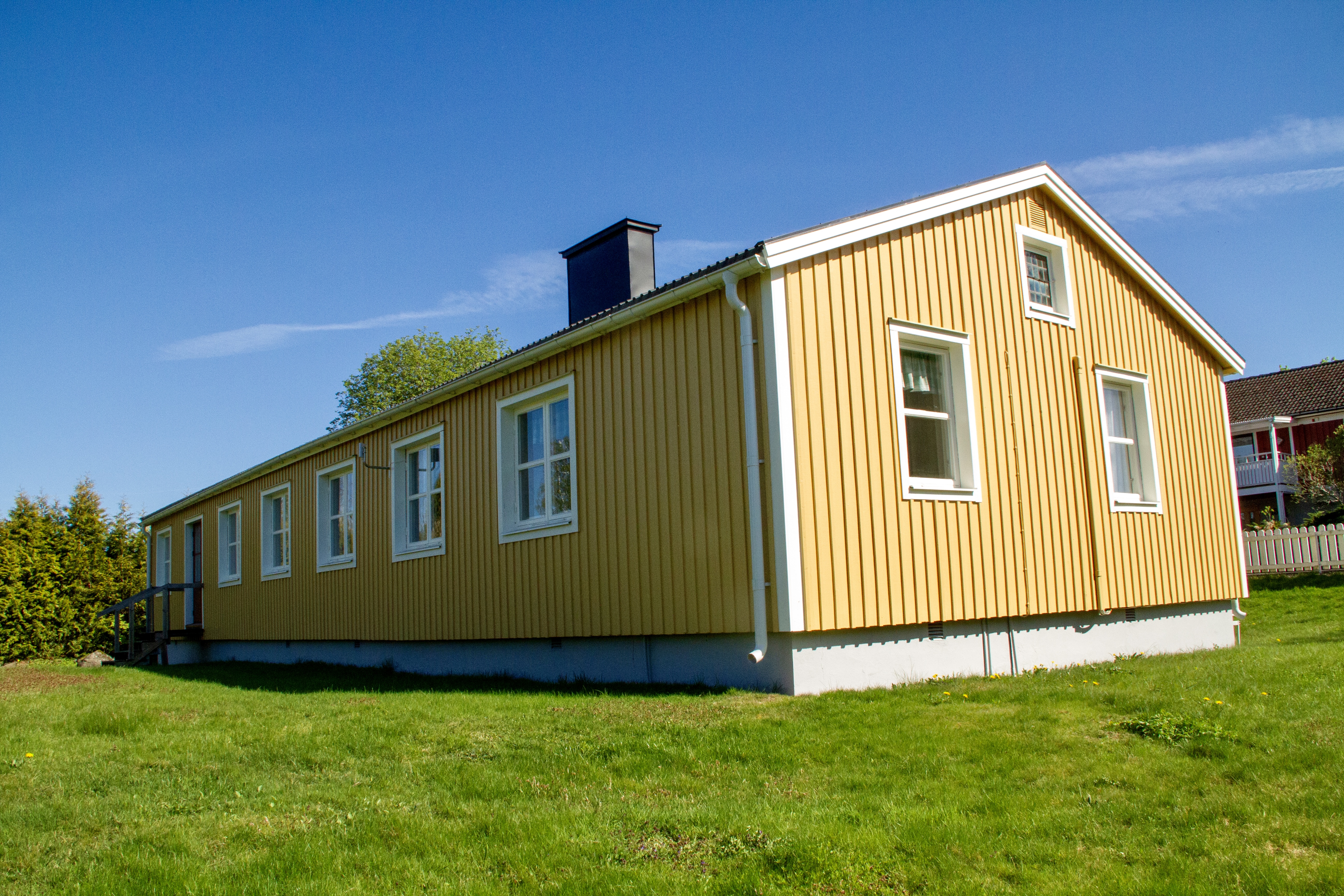 gult enplanshus med vita knutar