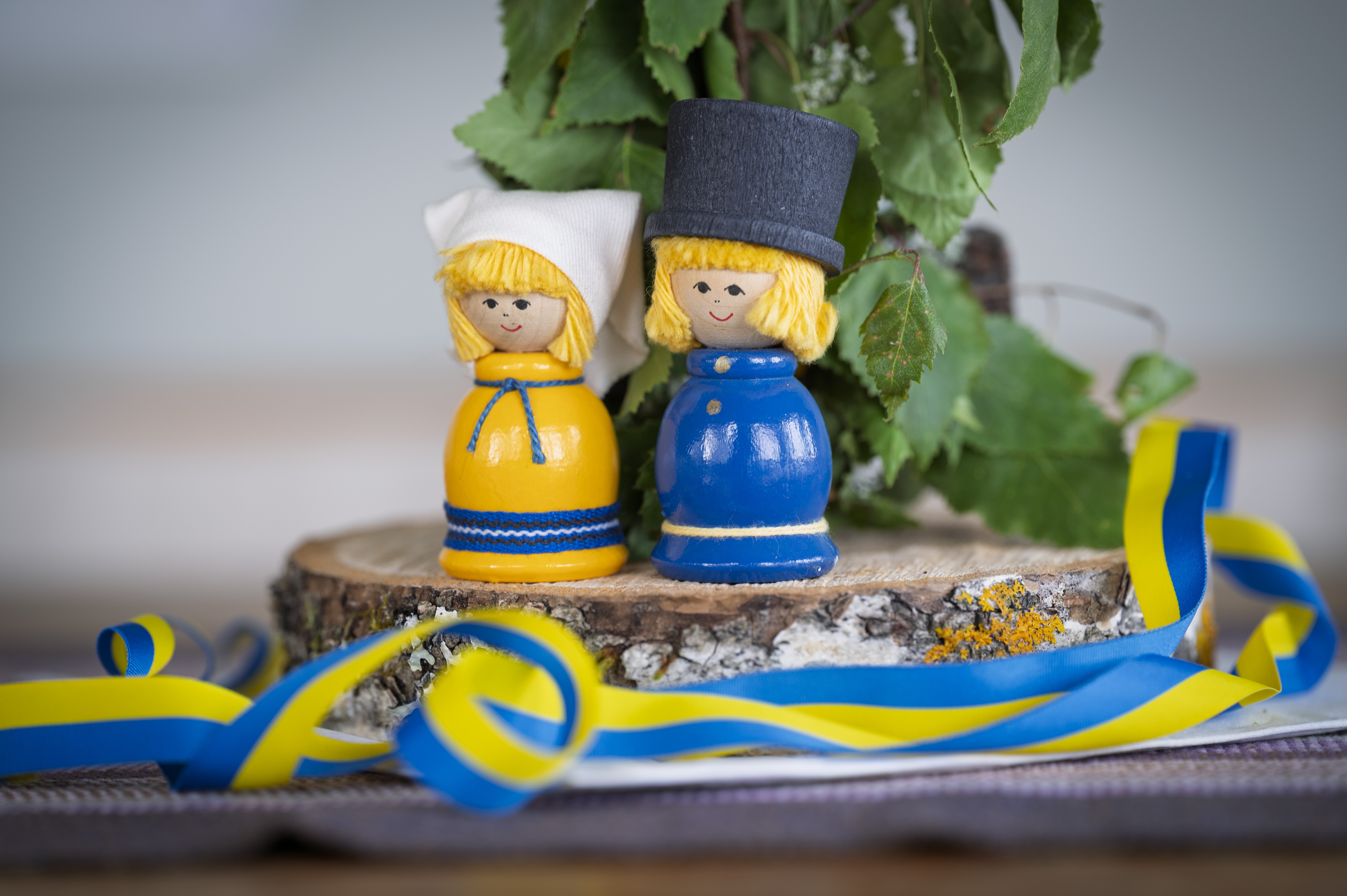 Figurer i blågula dräkter och svenska flaggan band.