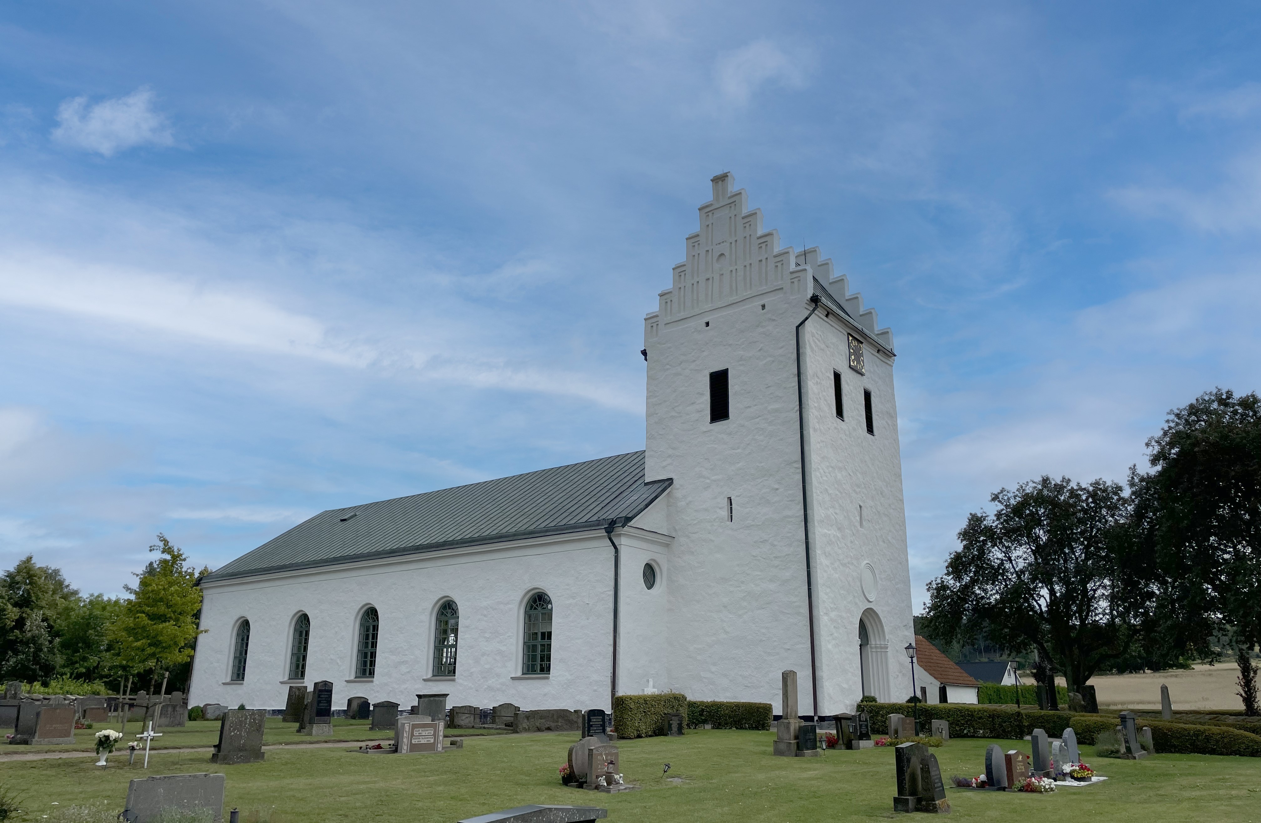 Vitkalkad kyrka mot blå himmel.