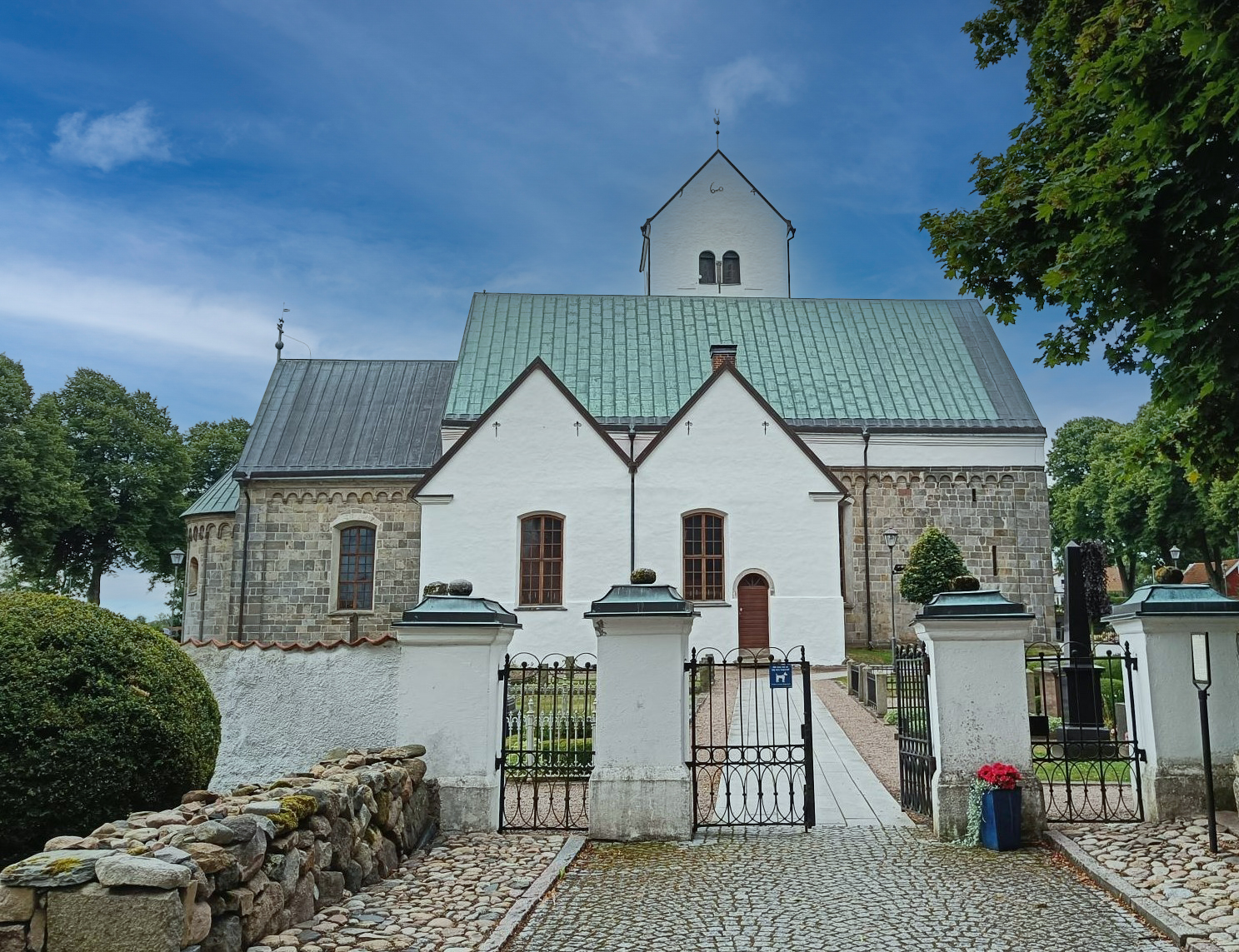 Vitkalkad kyrka mot blå himmel.
