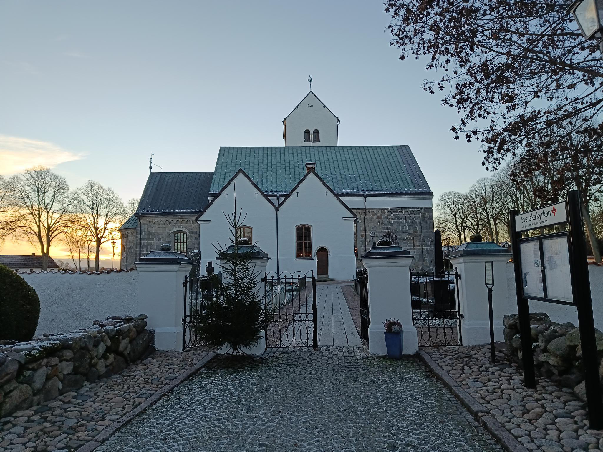 Vitkalkad kyrka mot blå himmel.