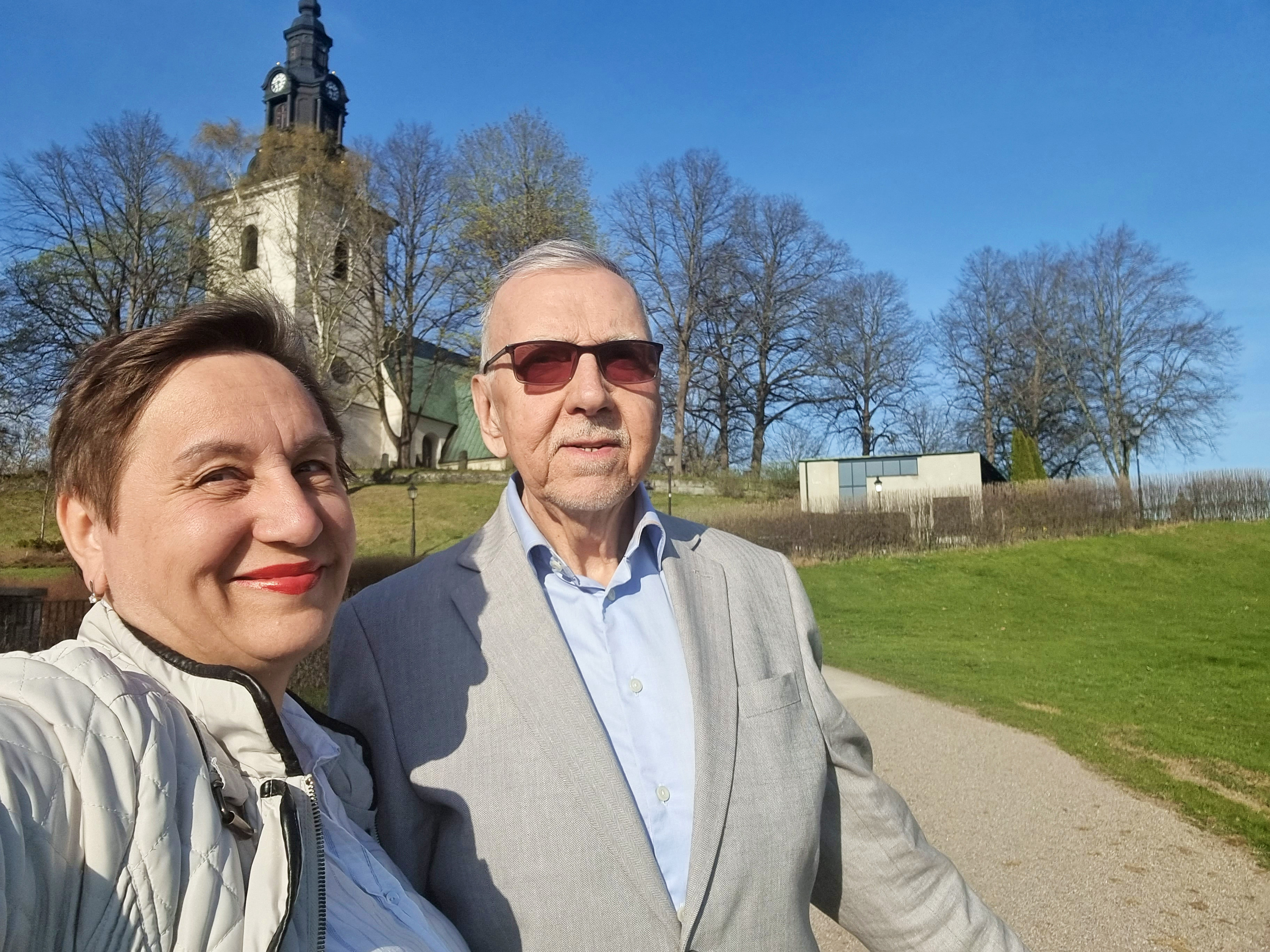 En kvinna och en äldre man med Västerlövsta kyrka i bakgrunden.