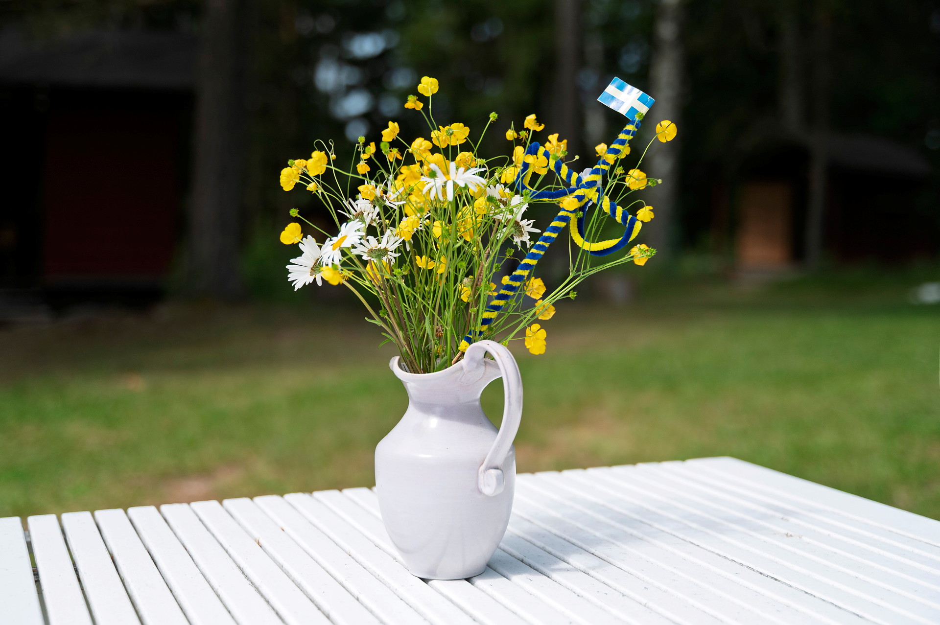 En vit tillbringare med midsommarblommor i