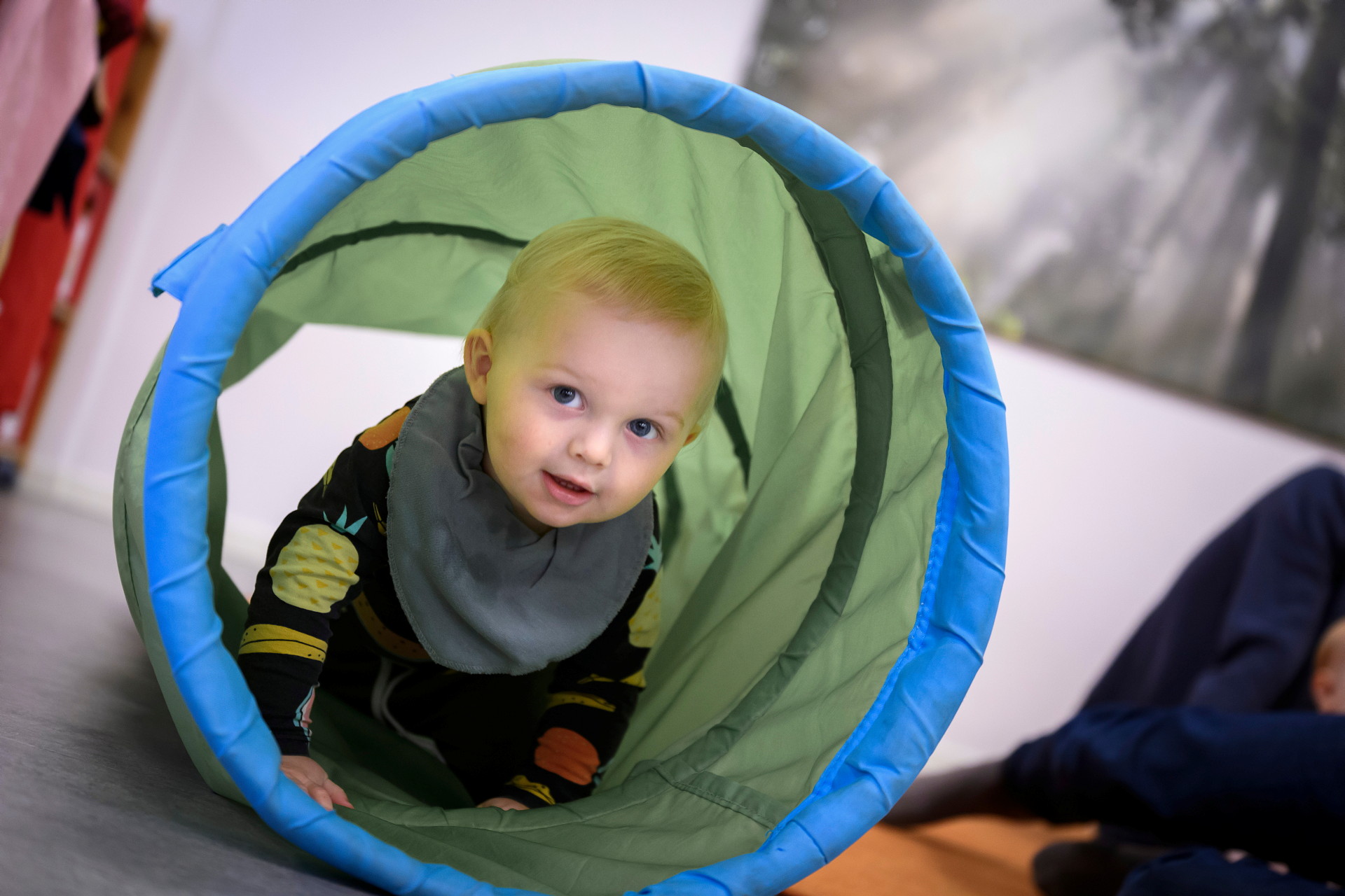 Litet barn tittar fram i en lektunnel