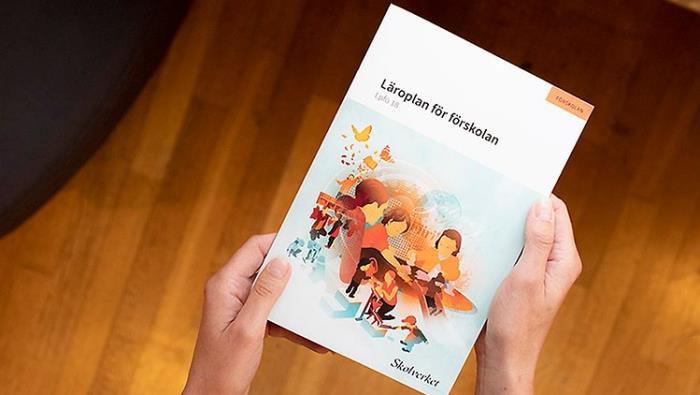 Någon håller i en folder om läroplanen