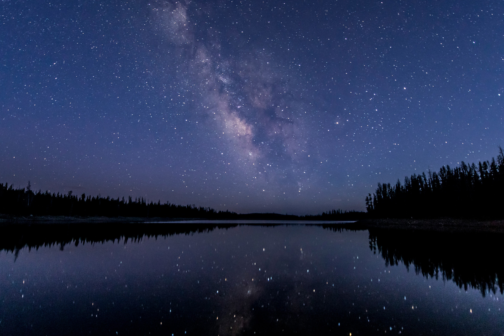 Stjärnhimmel reflekteras i en sjö.