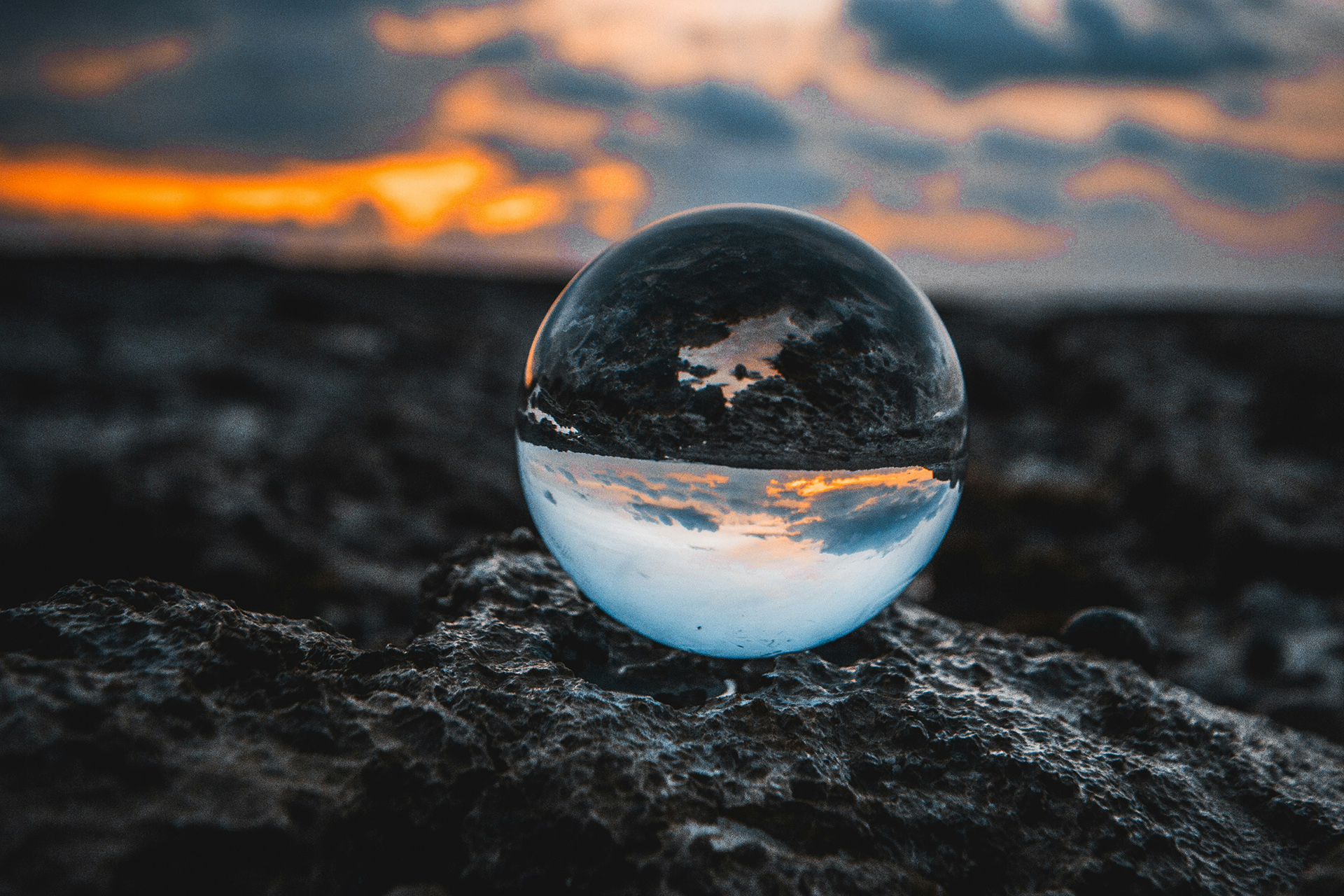 En fritt svävande glaskula speglar skymningshorisonten och ett mörkt landskap men reflektionen vänds upp ioch ner i själva klotet.