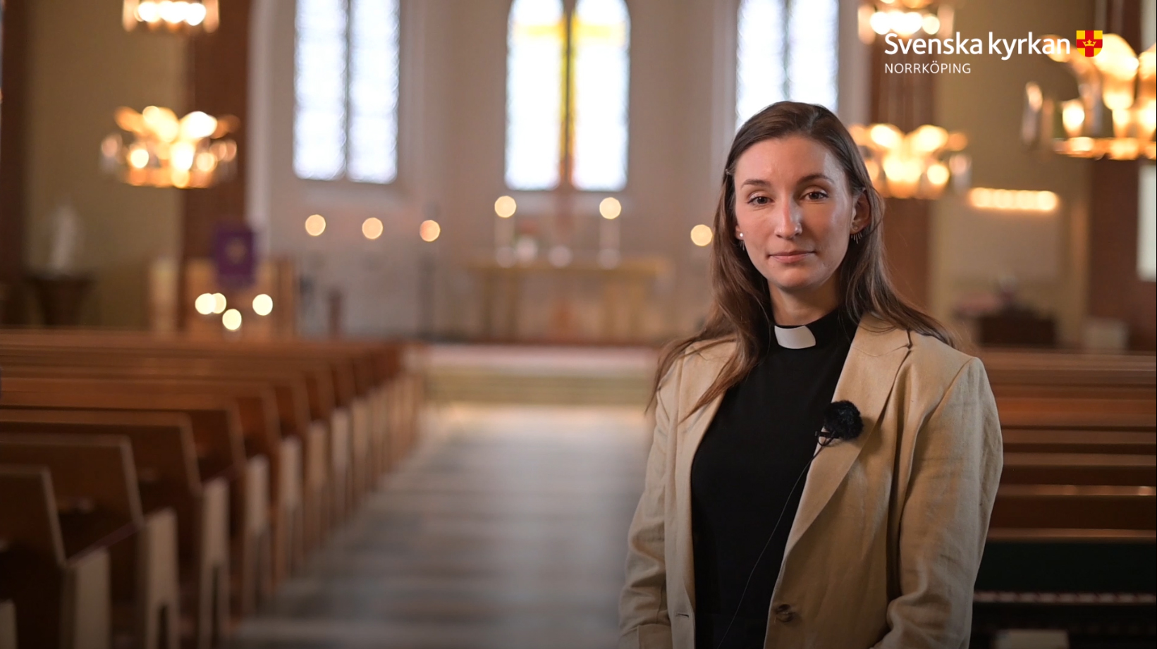 Prästen Sigrid med interiören av Krokeks kyrka i bakgrunden.