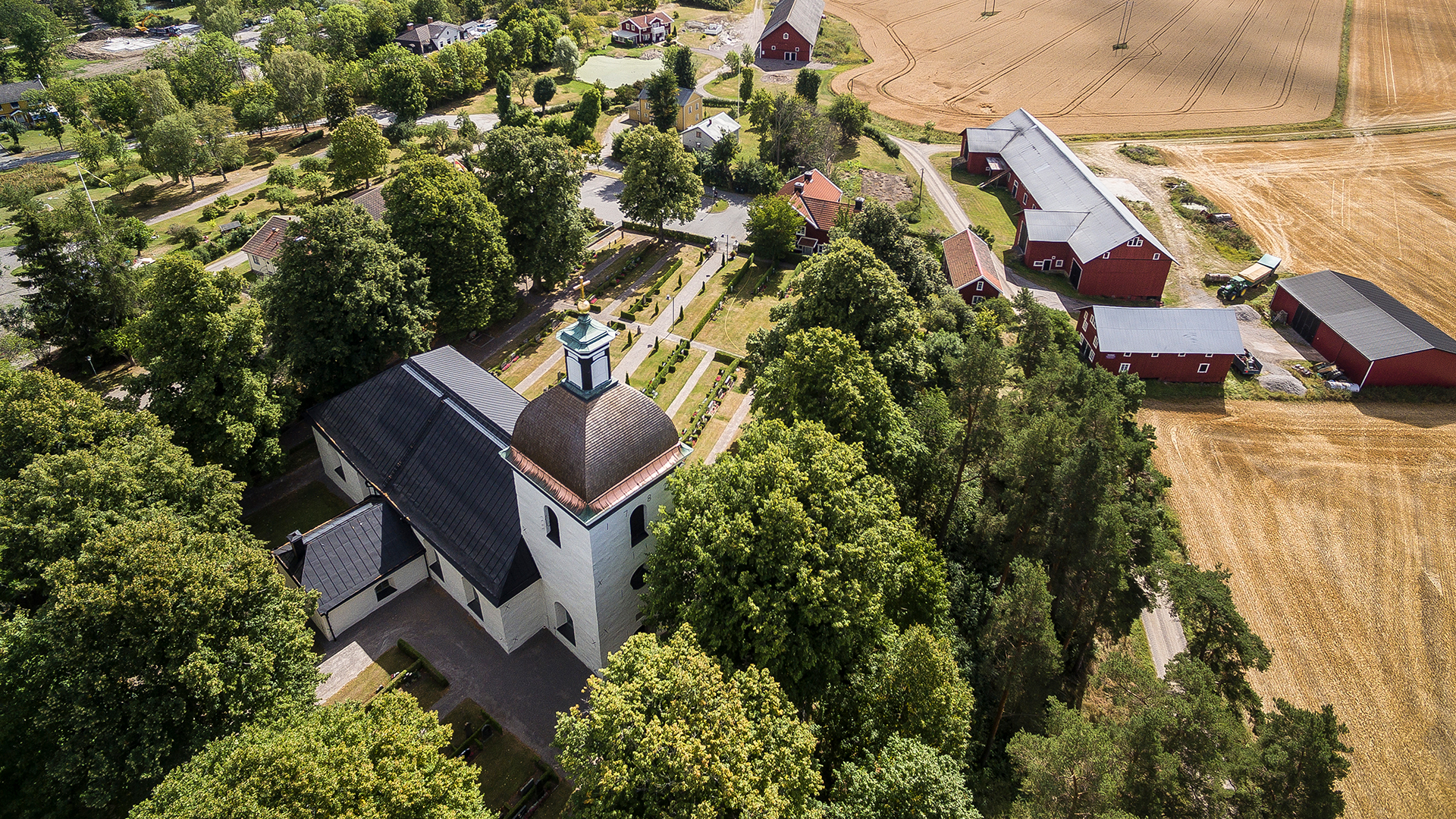 Drönarbild av Styrstad kyrka i lummig grönska.