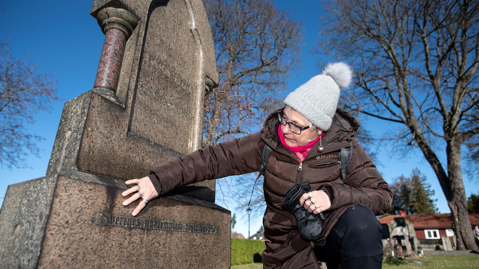 Helen Hagman Olsson framför en gravsten