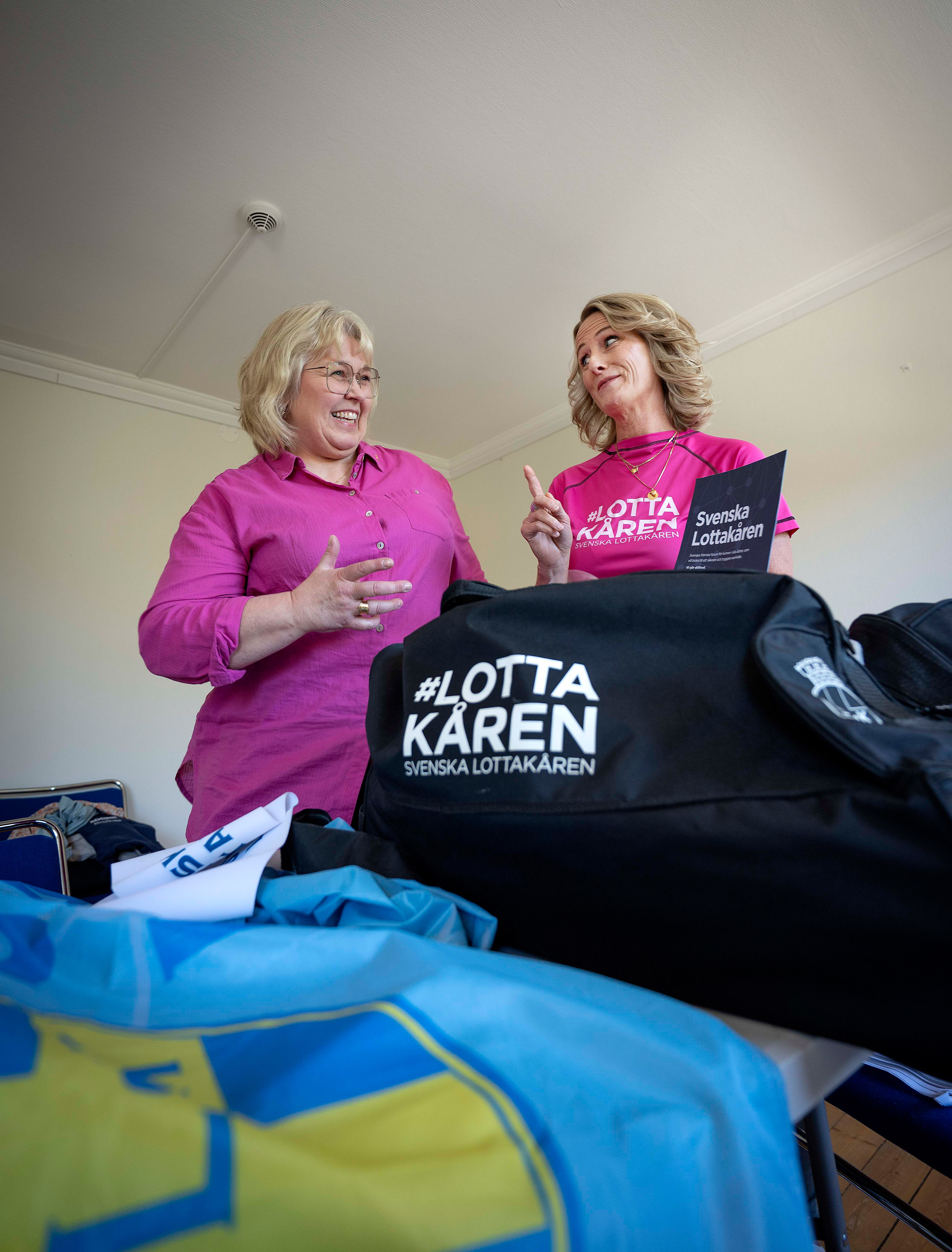 Mari och Viktoria står vid ett bord med en massa Lotta-material på