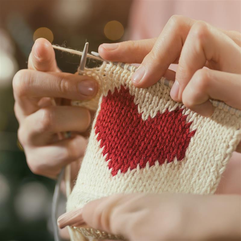 Två händer stickar