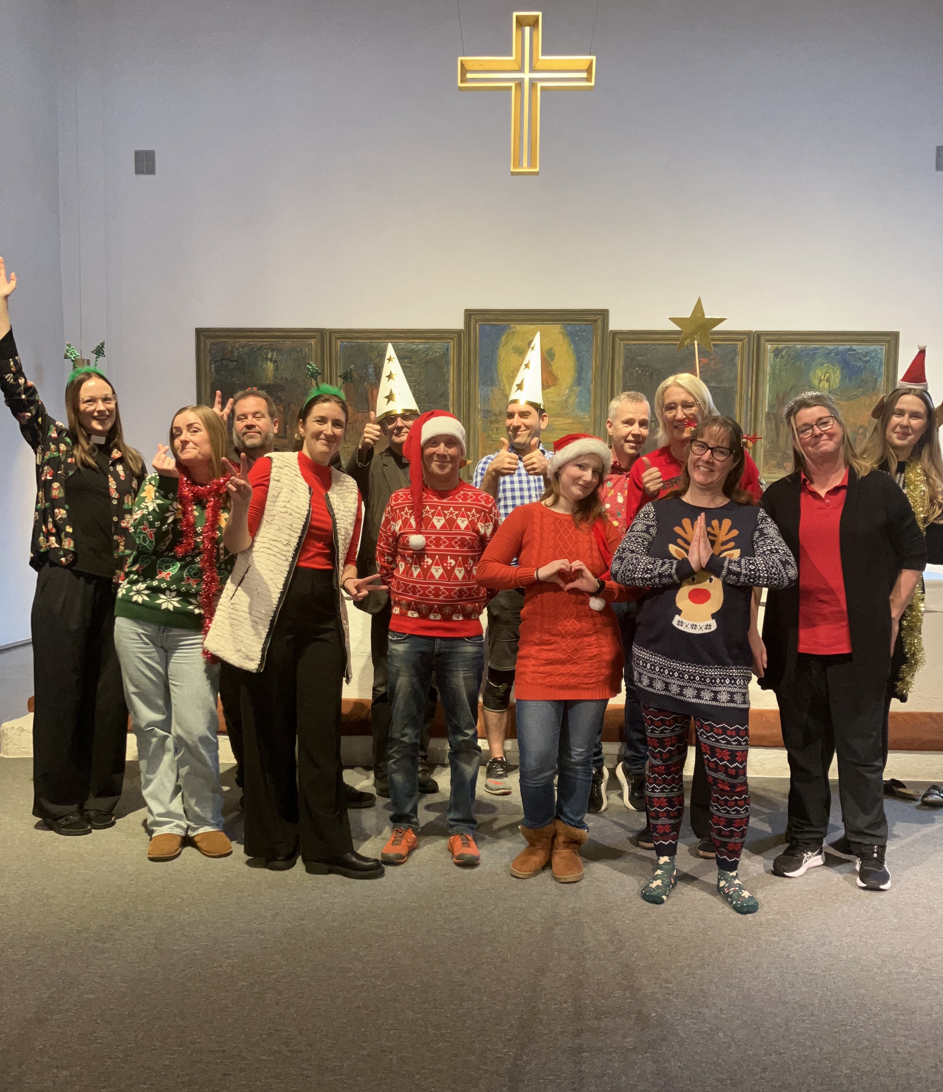 Personalen i Badelunda församling står i Tomaskyrkan framför altaret och ler mot kameran.
