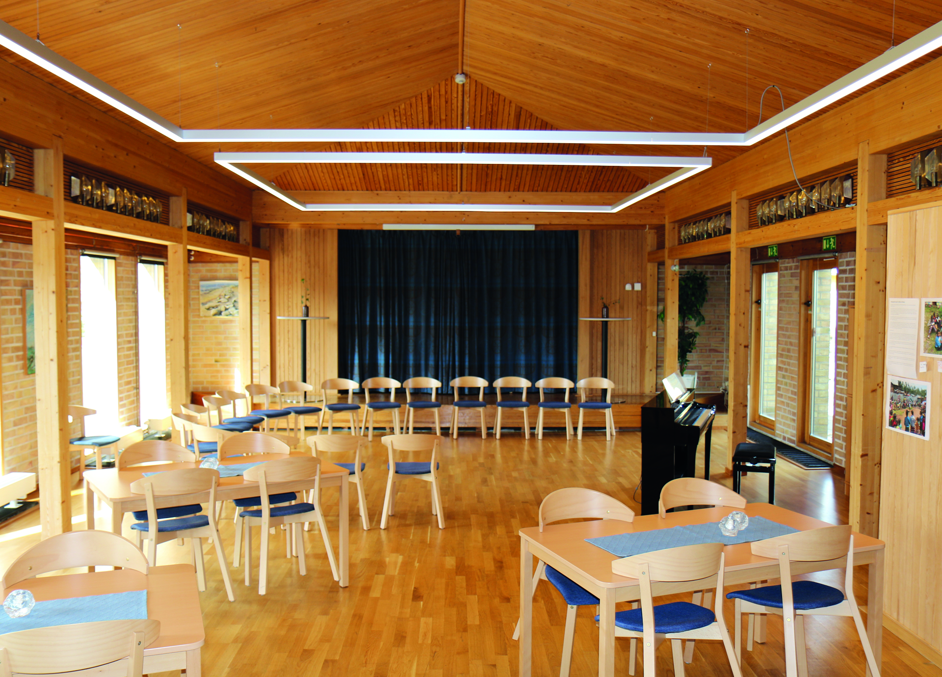 Bord och stolar. En scen samt ett piano.