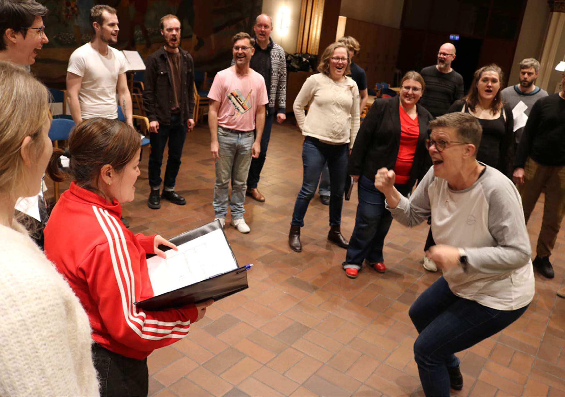 En körsångare som dirigerar och dansar med sin kör