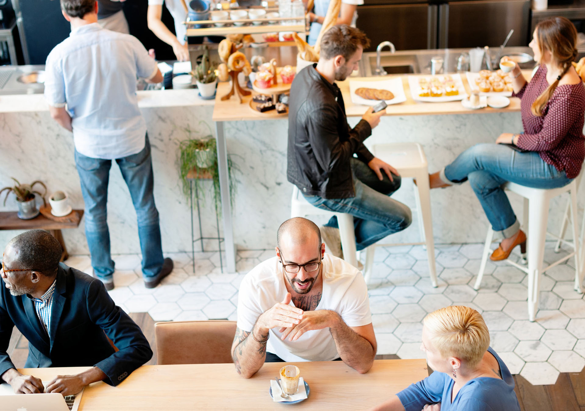 Människor vid olika bord på ett café som samtalar