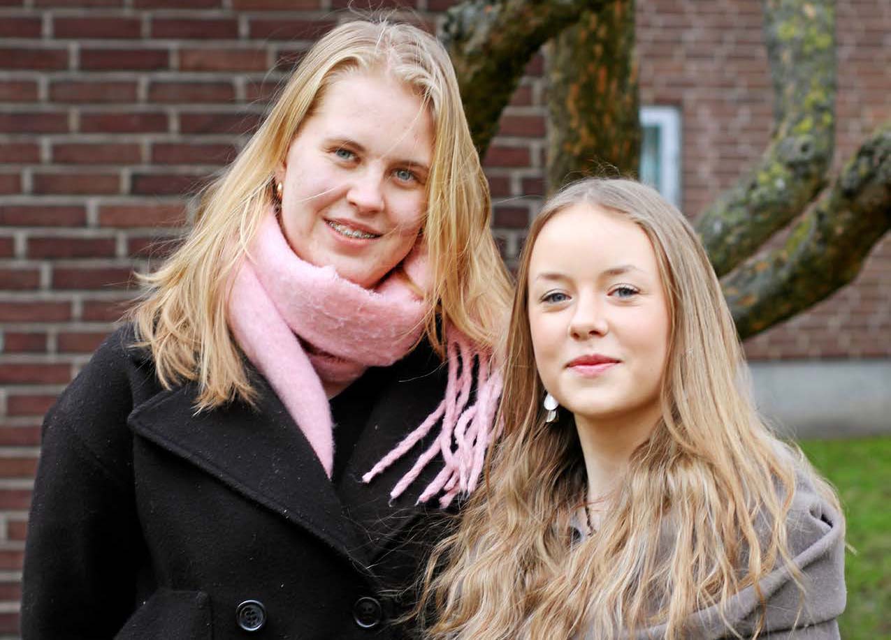 Två ungdomar i ytterkläder ler mot kameran