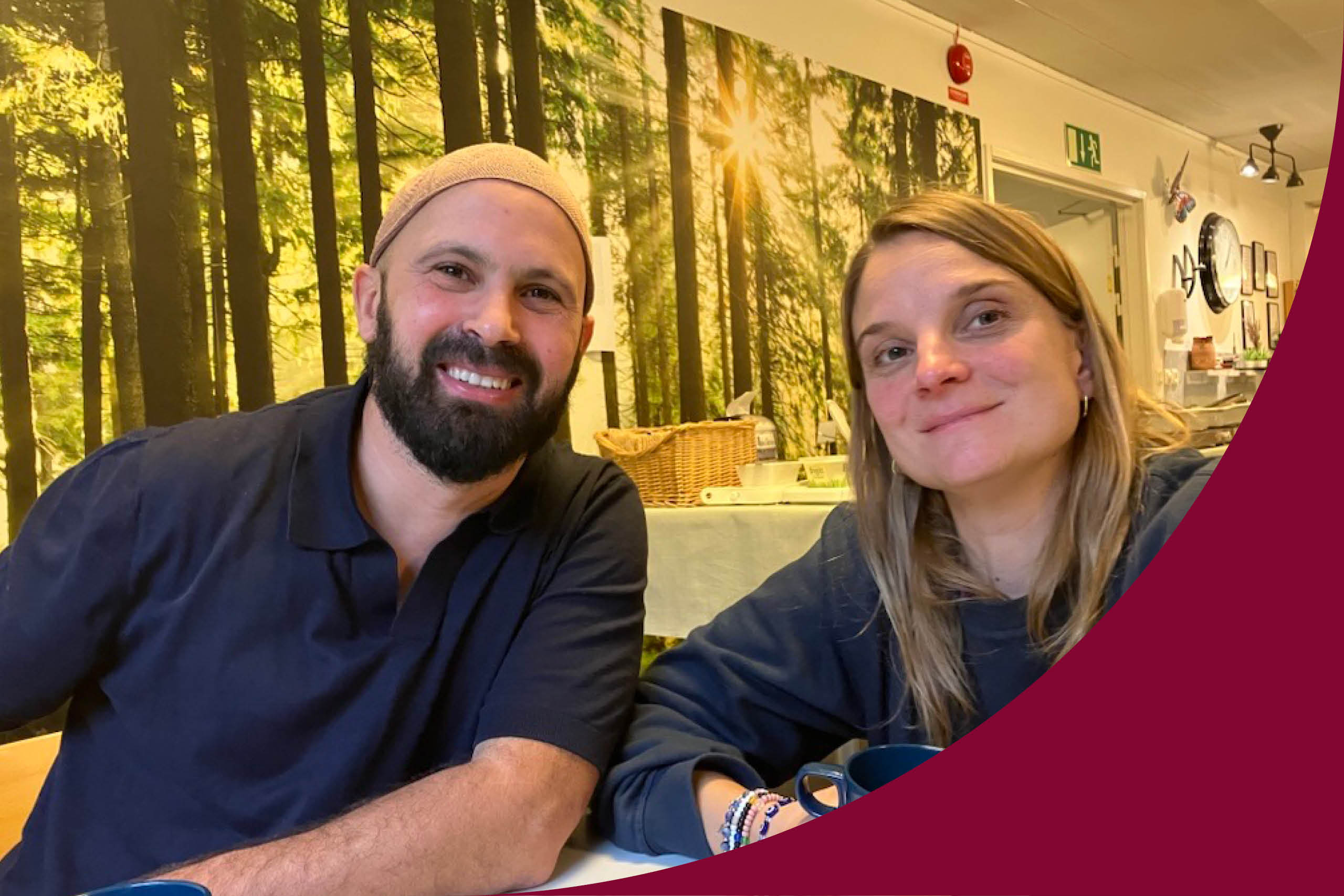 En man sitter till vänster i en blå tröja, han har skägg och en kufi på huvudet. Till höger sitter en kvinna i en mörkblå tröja, hon har långt brunt hår.