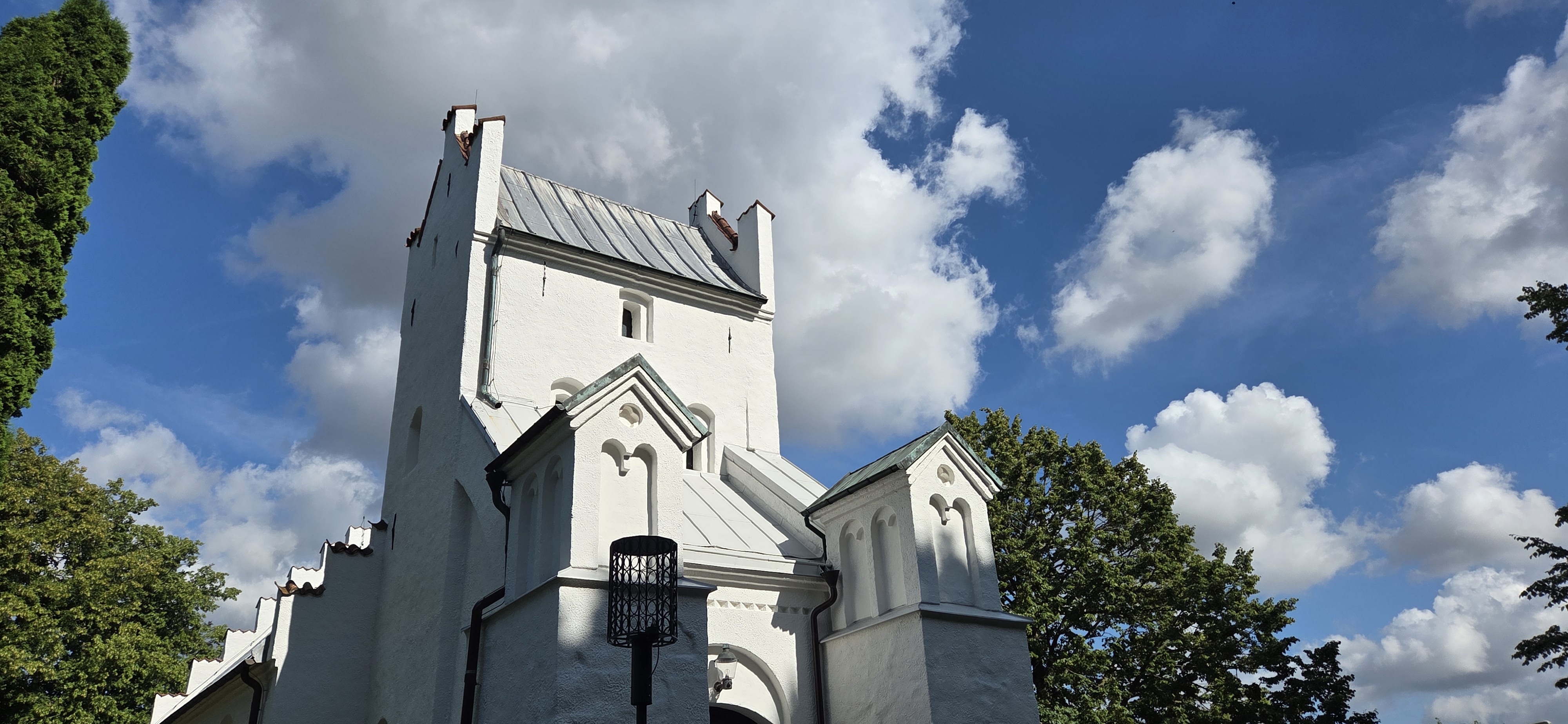Fasaden på en vit kyrka med blå himmel i bakgrunden