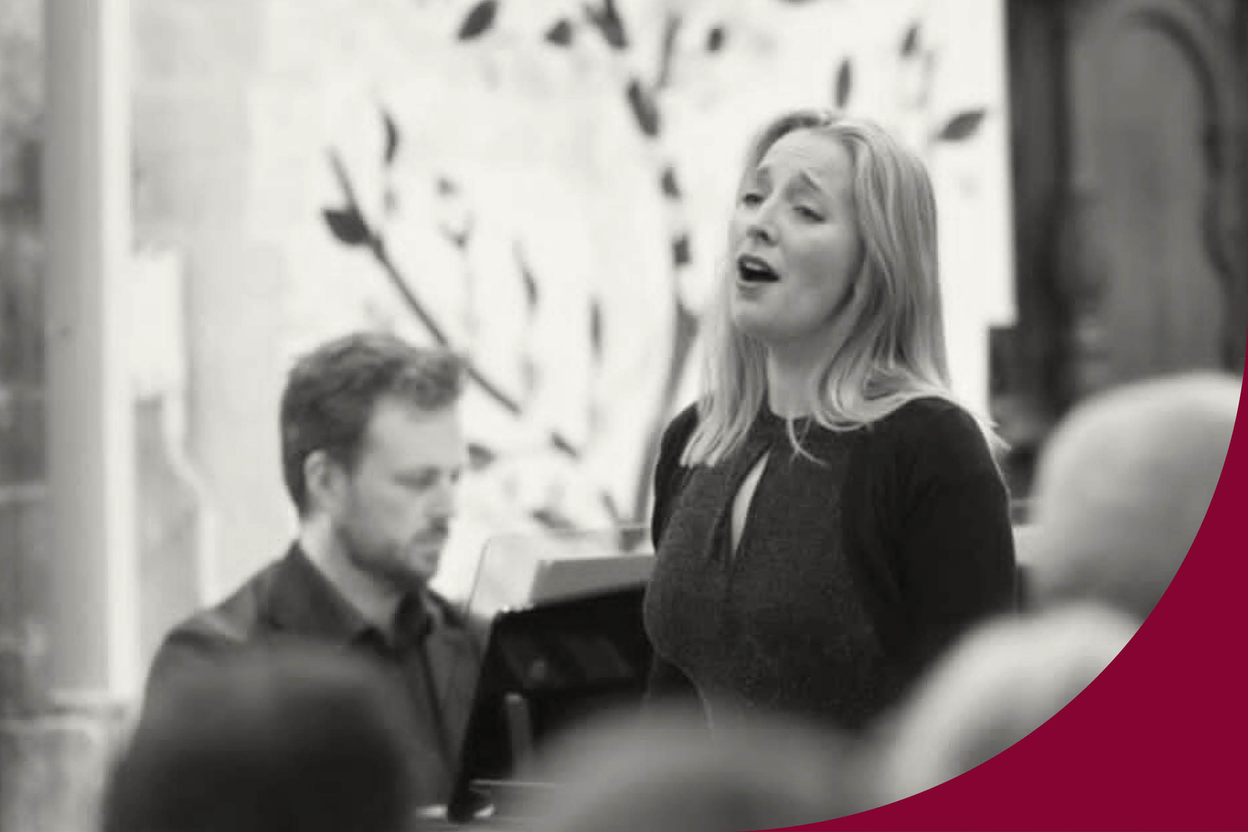 En svartvit bild där man ser en kvinna till höger som  sjunger. Hon har en mörk tröja och långt ljus utsläppt hår. Lite till vänster om henne ser man en man som spelar piano. Han har mellanblond kortklippt hår och skäggstubb. Han har en mörk skjorta på sig. 