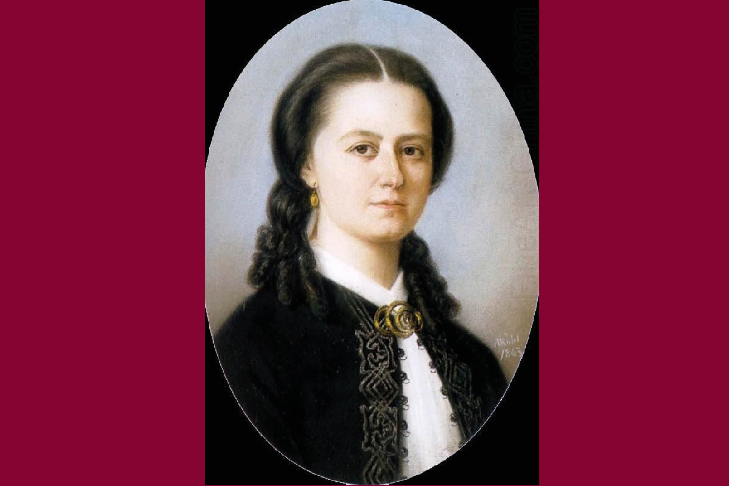 En bild på tonsättare Laura Netzel. Laura är avbildad i en svart jacka med silverbrokad i knappkanten. Jackan hålls ihop av ett guldfärgat spänne som sitter uppe vid halsen. Hon har axellångt mörkt hår som är slätt upp på huvudet och med lockar nedtill. I öronen har hon guldfärgade små hängande örhängen.