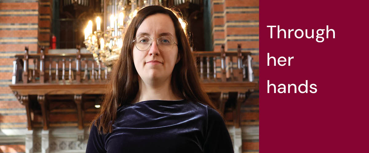 På bilden ser man Sofia. Hon har en blå sammetsklänning på sig, mörkt långt hår och glasögon. I bakgrunden ser man Allhelgonakyrkans orgel. 