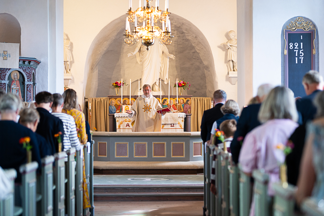 En präst sträcker ut sina armar i välsignelse