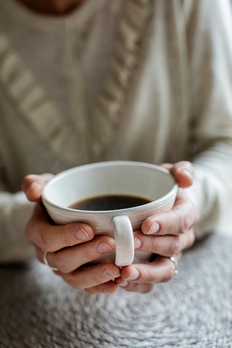 Händer som håller en kaffekopp