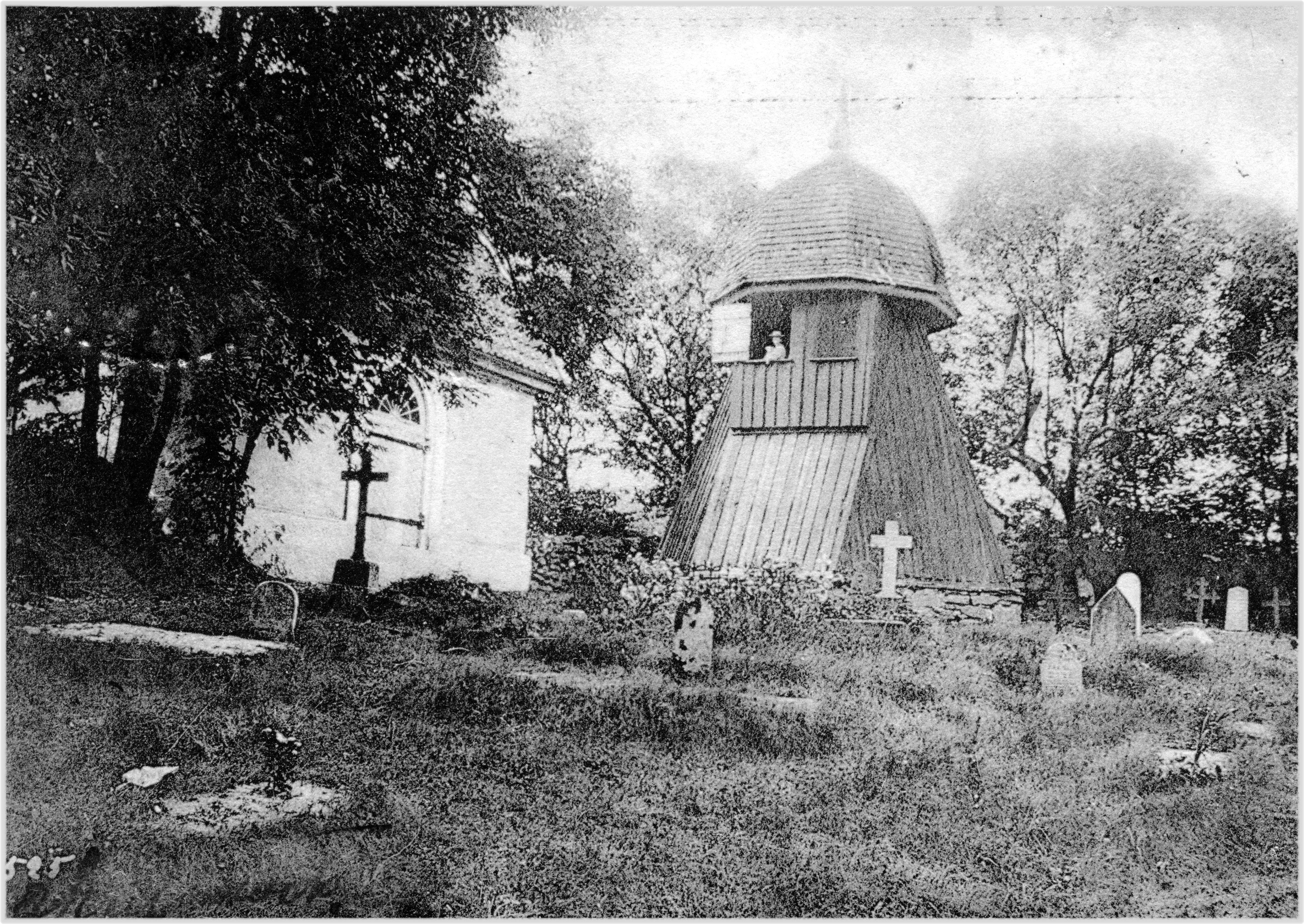 Svartvit bild på Kållereds kyrkogård från ca 1905. En flicka syns i klockstapelns lucka.