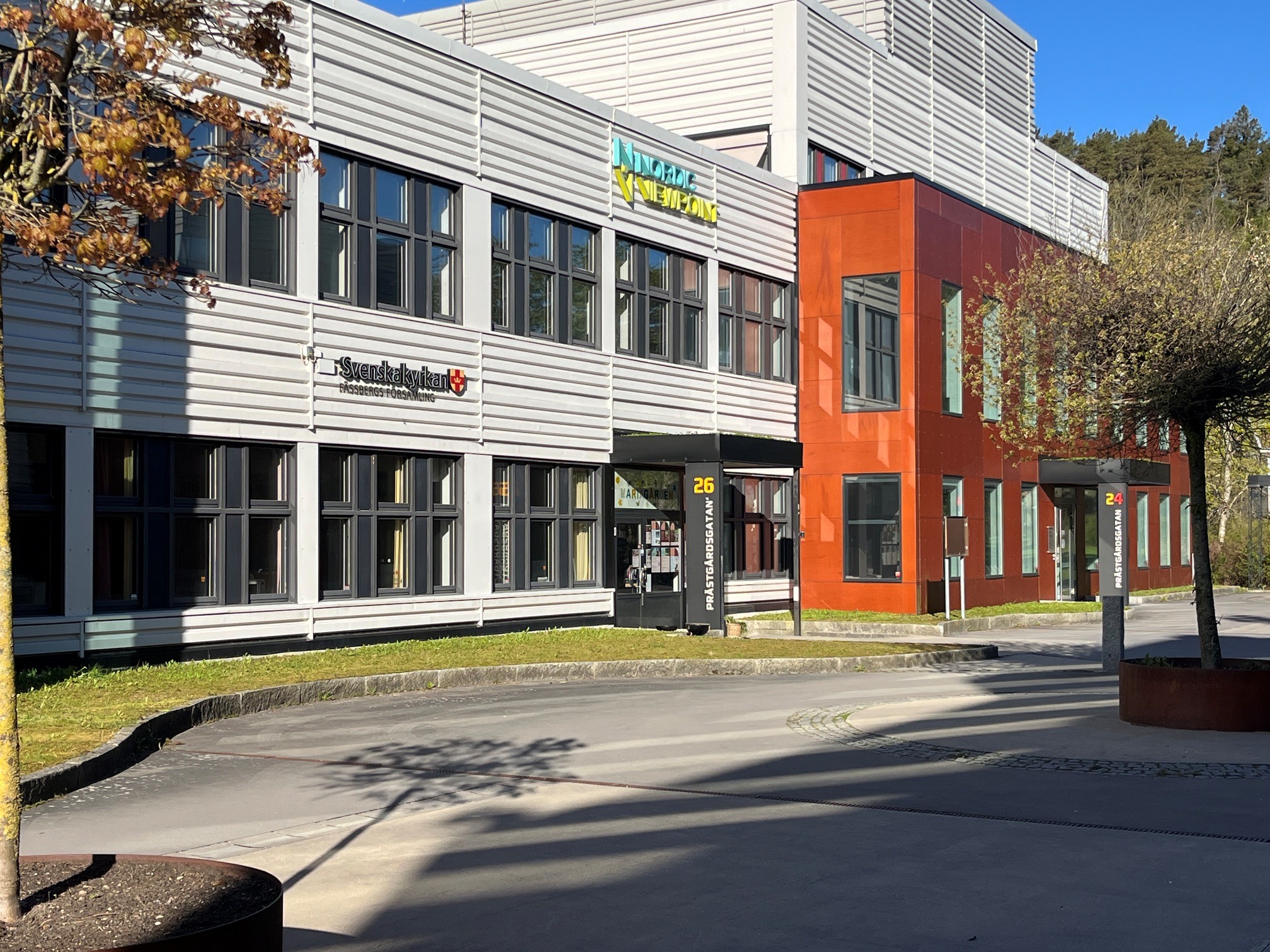 Mariagården, Pedagogen park. Ett grått hus och en röd byggnad på den. En port med tak in till lokalerna.
