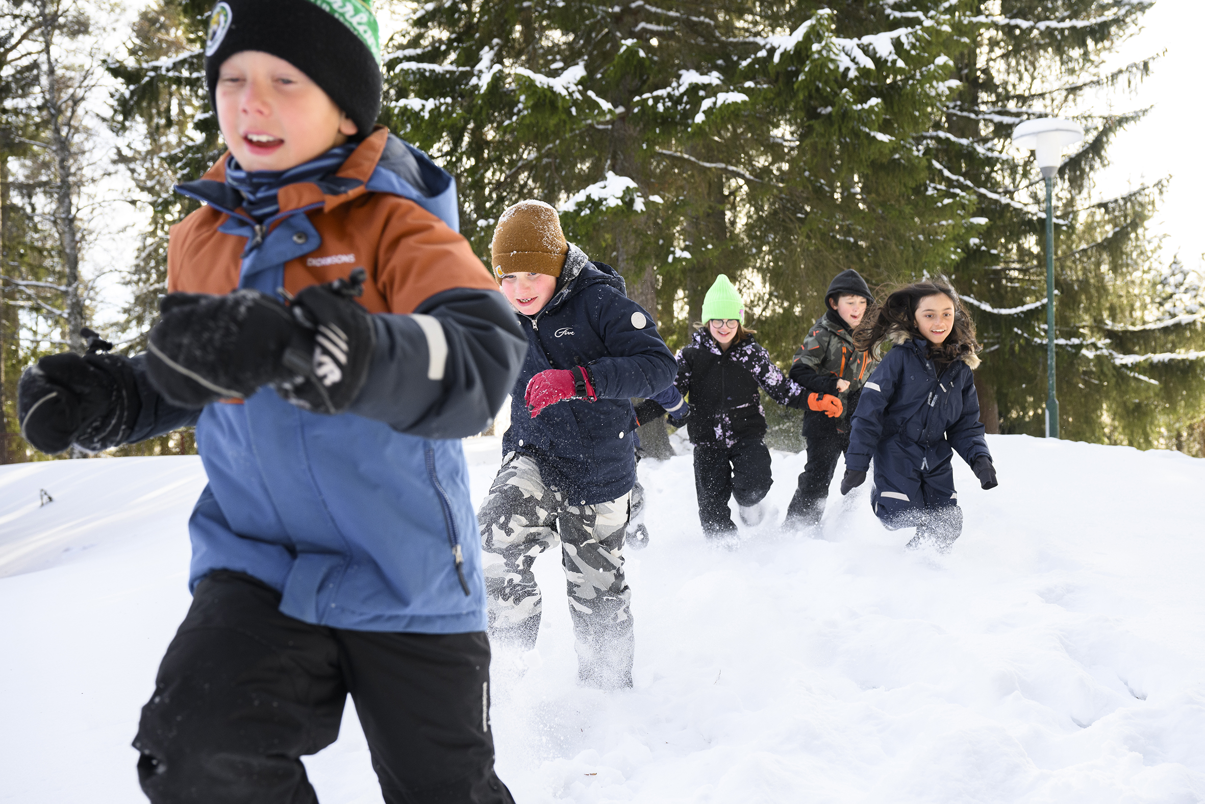 Barn i mellanstadieåldern springer i snön