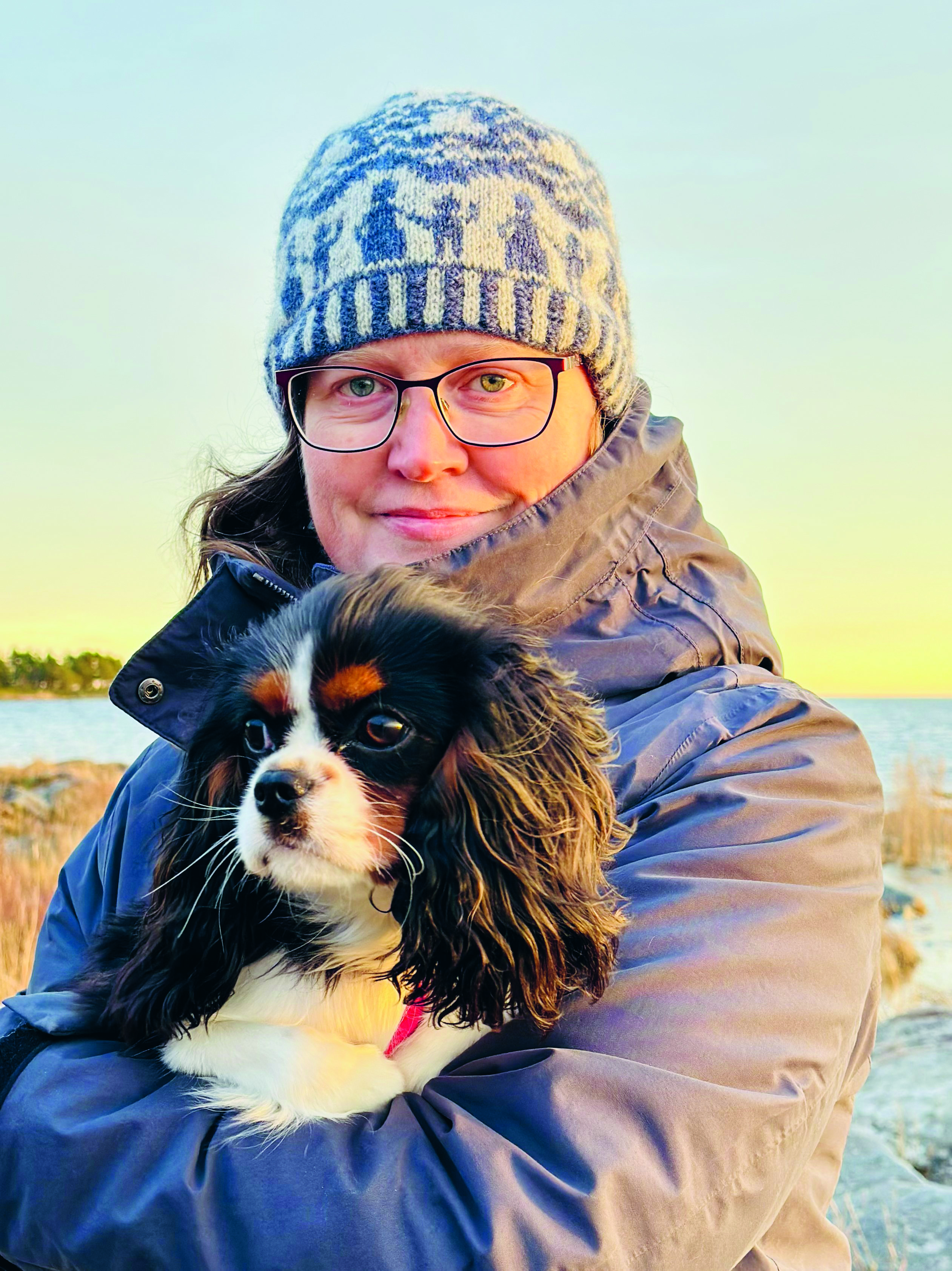 Charlotte har Tillsammansmössan på sig på en naturskön plats vid en sjö.