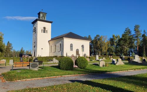 Överluleå kyrka omgiven av den gamla kyrkogården.